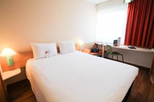 a hotel room with two beds and two lamps at ibis Hotel Düsseldorf Hauptbahnhof in Düsseldorf