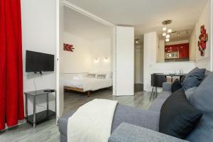 ein Wohnzimmer mit Sofa und TV in einem Zimmer in der Unterkunft Apartment Jonquille 2C in Chamonix-Mont-Blanc