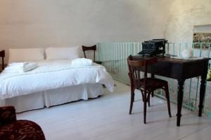 um quarto com uma cama e uma secretária com uma máquina de escrever em Albergo Diffuso Il Casale em Ginosa