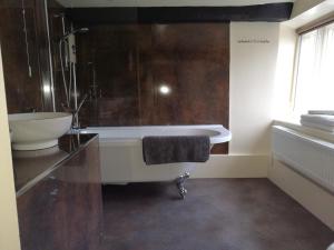 a bathroom with a bath tub, toilet and sink at Longbridge House in Shepton Mallet