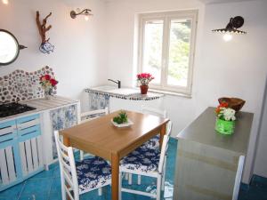 a kitchen with a table and chairs and a window at Le Case dei Pescatori - Mare Blu in Ponza