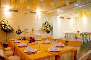 a room with tables and chairs with yellow tablecloths at Hotel Castell - Cerca Del Aeropuerto in Guayaquil