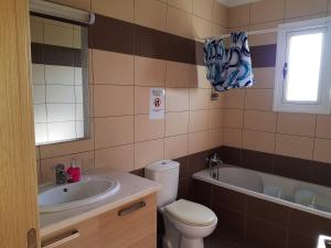 a bathroom with a toilet and a sink and a tub at Mazotos Panoramic Village in Mazotos
