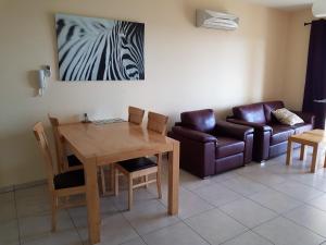 a living room with a table and a couch at Mazotos Panoramic Village in Mazotos