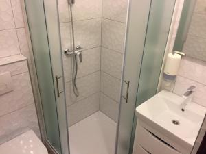 a bathroom with a shower, sink, and toilet at Rooms & Pansion Odmor in Rovanjska