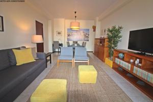 a living room with a couch and a table and a tv at Bombarda House & Home in Porto