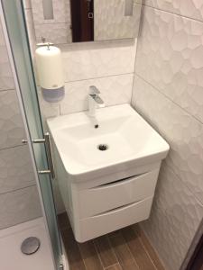 y baño con lavabo blanco y ducha. en Rooms & Pansion Odmor, en Rovanjska