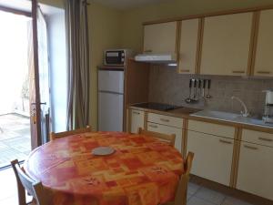 cocina con mesa con sillas y cocina con fregadero en Domaine de La Tour, en Salavas