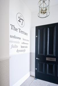 uma porta preta num quarto branco com uma placa em 27 The Terrace em St. Ives