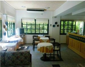 a room with two beds and a table and chairs at Rea Hotel in Palaiochora