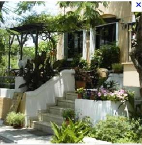 a house with stairs and plants in front of it at Rea Hotel in Palaiochora +11 photos