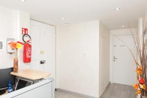 a kitchen with white walls and a red fire extinguisher at Foresteria Boccadasse in Genoa