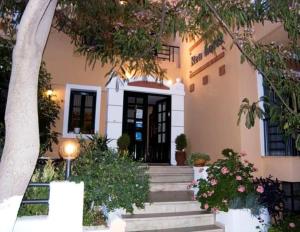 a house with stairs leading up to a door at Rea Hotel in Palaiochora