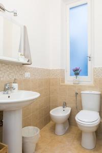 a bathroom with a sink and a toilet and a window at Foresteria Boccadasse in Genoa
