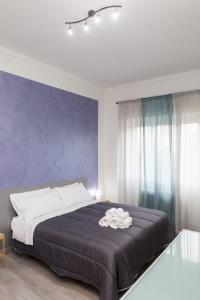 a bedroom with a large bed with a purple wall at Foresteria Boccadasse in Genoa