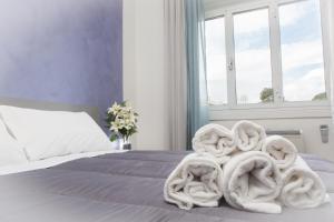 a bed with a pile of towels on it at Foresteria Boccadasse in Genoa