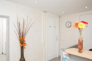 a room with two vases with flowers on the wall at Foresteria Boccadasse in Genoa
