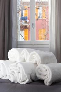 a pile of white towels sitting in front of a window at Foresteria Boccadasse in Genoa