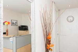 a hallway with a mirror and a desk and a clock at Foresteria Boccadasse in Genoa