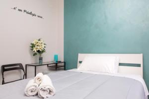a bedroom with a white bed with towels on it at Foresteria Boccadasse in Genoa