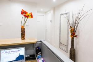 an office with two vases with flowers in it at Foresteria Boccadasse in Genoa