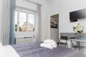 a bedroom with a bed and a table and a window at Foresteria Boccadasse in Genoa