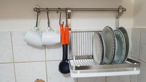 un appendiabiti con piatti e utensili in cucina di Elisavet Apts a Kávos Altre 104 foto