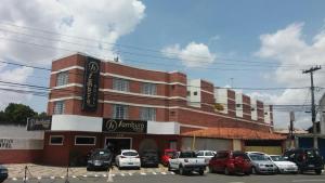 a building with cars parked in front of it at Sambura Hotel in Feira de Santana