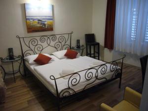 斯普利特B&B Central Palace Heritage的卧室里有一张床，床单是白色的，枕头是橙色的