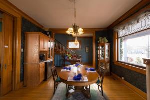 a dining room with a wooden table and chairs at Astor House in Green Bay