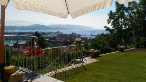 a view of the ocean from a garden with an umbrella at Casa Isabelle in La Spezia