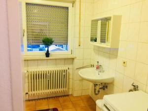 uma casa de banho com um lavatório e uma janela em Ferienwohnung Dhillon em Bernau am Chiemsee