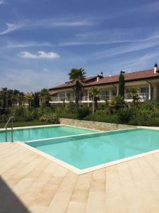 a large swimming pool in front of a house at Luxury Apartments Beauty Gardens in Sirmione