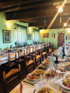 een eetkamer met lange tafels met borden eten bij Agriturismo Santu Marcialis in Dolianova