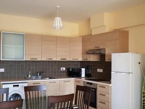 a kitchen with a white refrigerator and wooden cabinets at Mazotos Panoramic Village in Mazotos