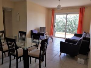a living room with a glass table and chairs at Mazotos Panoramic Village in Mazotos