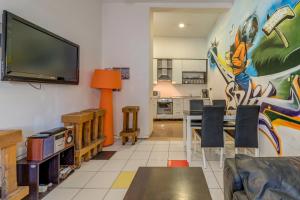sala de estar con TV y mesa con sillas en Adriatic Hostel - Youth Only, en Split