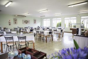 a large room with tables and chairs and windows at Pousada Betânia in Curitiba