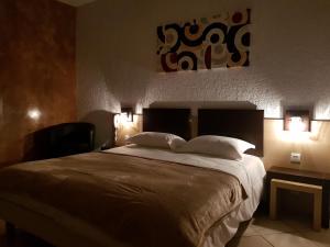 a bedroom with a large bed with two lights on it at Hotel & Restaurant le Saint Jean in Cargèse