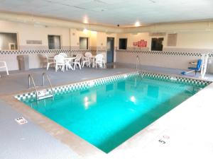 a large swimming pool with blue water in a building at Baymont by Wyndham Clinton in Clinton