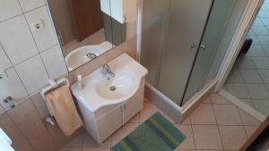 a white bathroom with a sink and a shower at Apartments Ana in Grebaštica +31 photos