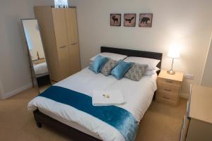 ロンドンにあるRoyal Limehouse Apartmentのベッドルーム(青い枕の大型ベッド1台付)