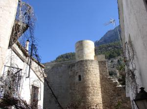 a large stone building with a clock on it's side at La Cueva de Juan Pedro in Cazorla