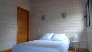 a bedroom with a bed and a wooden wall at Le Barail 31 in Couret