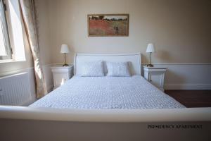 1 dormitorio con 1 cama blanca y 2 almohadas en Presidency House Self Check-in Apartments, en Sofía