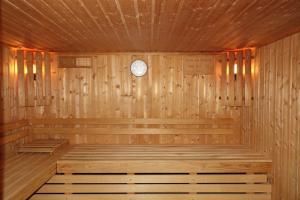 a wooden sauna with a clock on the wall at Hotel-Spa & Restaurant Logis Domaine Langmatt in Murbach