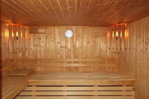 un sauna en bois avec une horloge sur le mur dans l'établissement Hotel-Spa & Restaurant Logis Domaine Langmatt, à Murbach