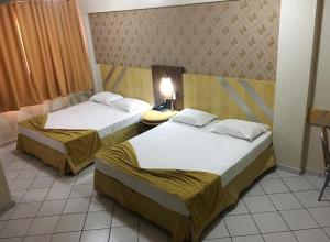 two beds in a hotel room with at King Konfort Hotel in Maringá