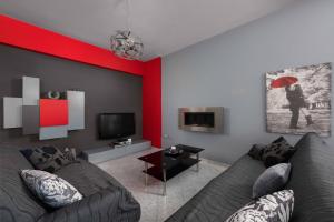 a living room with a couch and a red wall at S&A Amazing Sea View Apartment in Rhodes Town