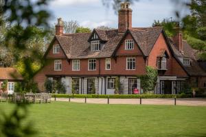 a large house with a lawn in front of it at Ravenwood Hall Hotel in Bury Saint Edmunds